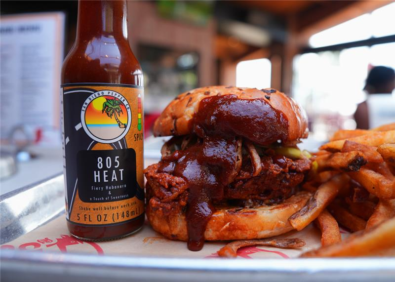 805 Heat from San Diego Pepper Company next to a chicken sandwich from the Crack Shack